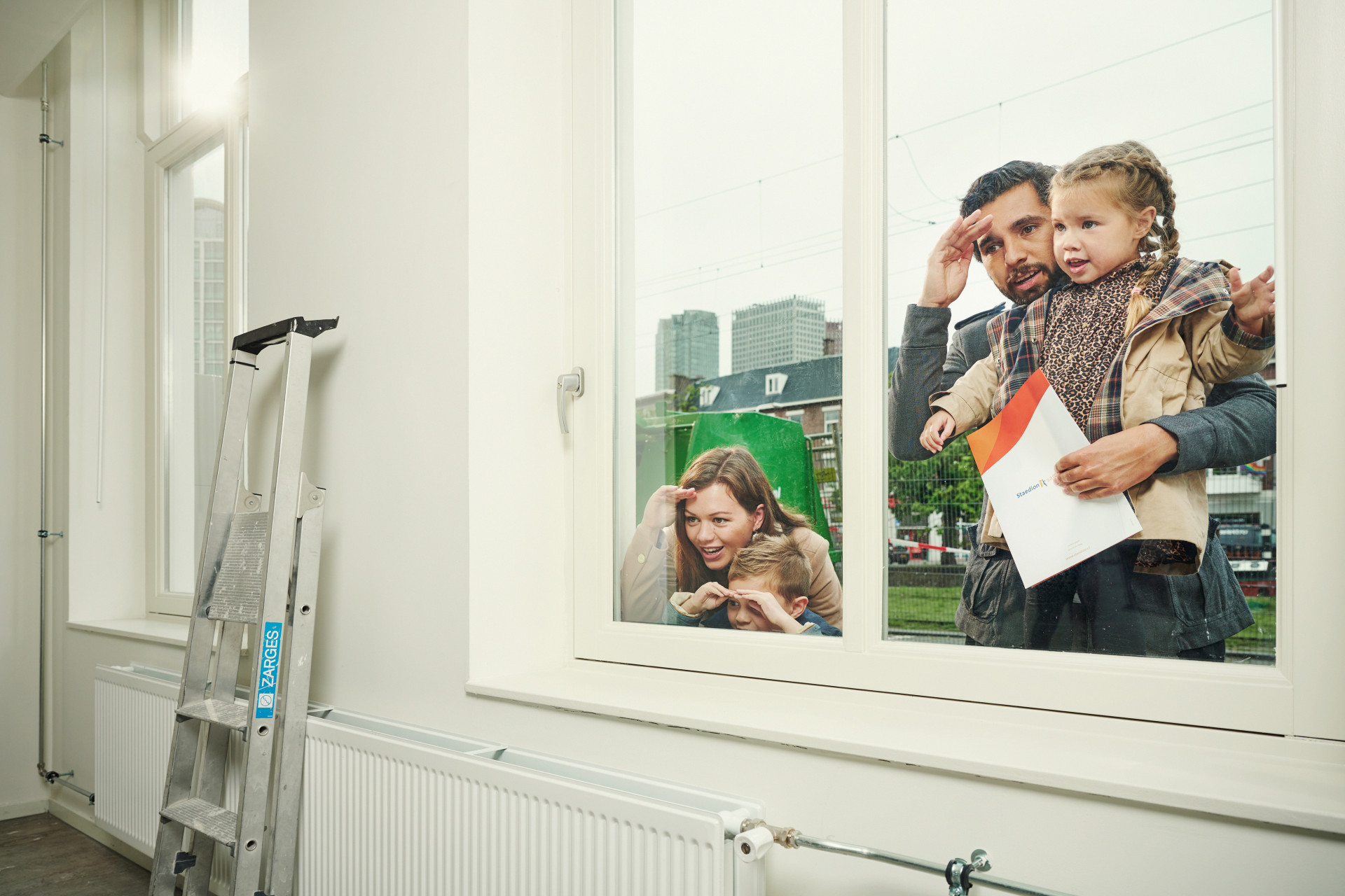 Een familie kijkt nieuwsgierig door een raam naar binnen.